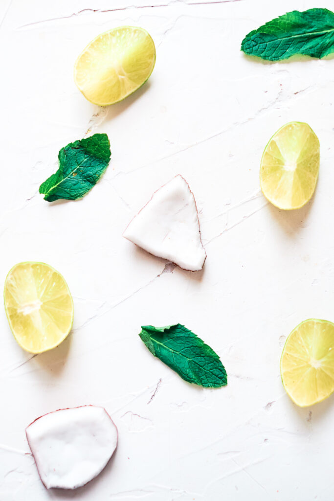 Food coconut pieces, mint leaves, and lemon wedges