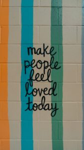 Writing on the wall saying Make people feel loved today.