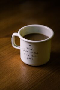 Coffee cup saying "What good shall I do this day"