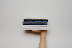 stack of books with hand