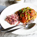 Plate of Jambalaya with slaw and blue checked towel
