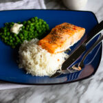 Salmon, rice and peas on blue plate.