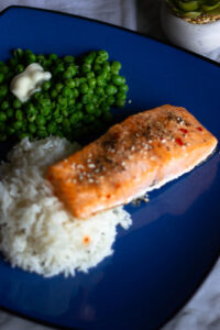 Salmon, rice and peas on blue plate.