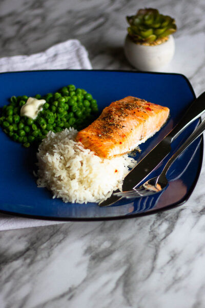 Salmon, rice and peas on blue plate.