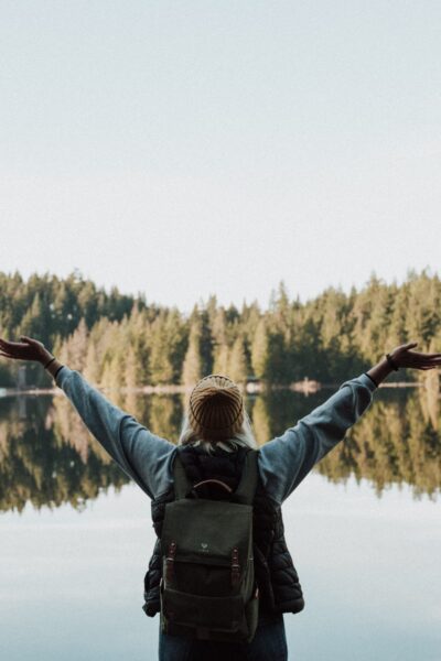 looking at lake with arms raised having margin in life