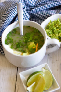 bowl of Chicken Tortilla soup with guac and lime
