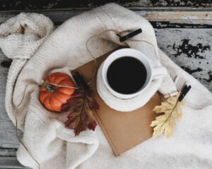 Cozy coffee, blanket and fall home decor.