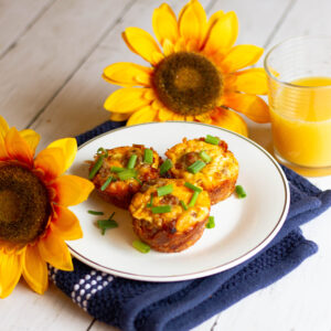 hash brown egg nests on plate with sunflower and juice