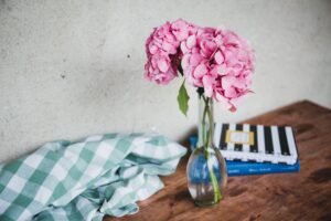 pink flowers in a vase with books on a table
