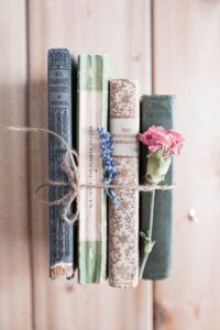 old books tied with string and a pink carnation