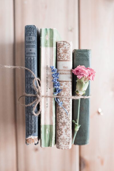 old books tied with string and a pink carnation