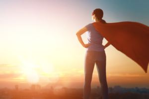 Woman in sunset with cape- superwoman