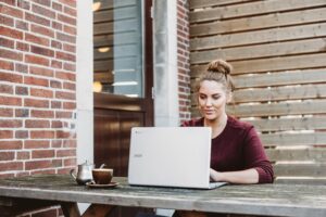 Female working on laptop outdoors on table