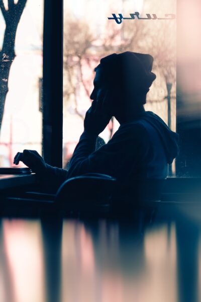 Shadow of person working on laptop at coffee shop