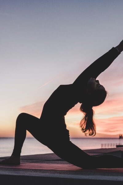woman doing yoga in front of sunset