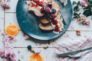 pancakes and fruit on plate on farmhouse table