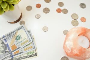 coins, bills, and candle on desk