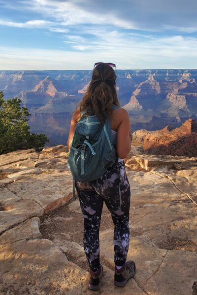 Woman with backpack looking over cliff