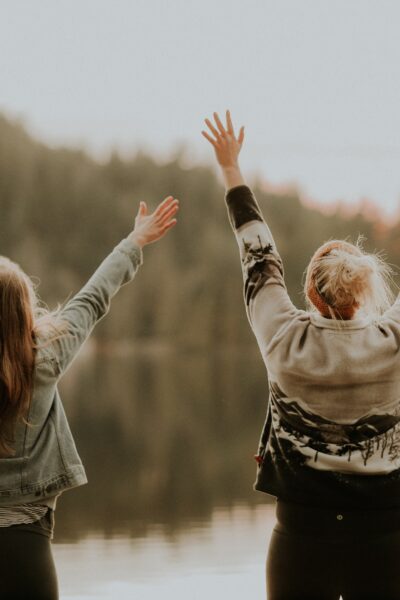 2 women from back with arms raised celebrating