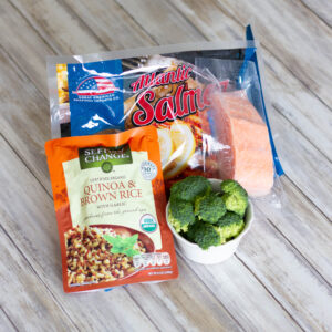 packaged frozen salmon, quinoa, and raw broccoli as ingredients for dinner