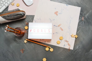 pink and gold desktop with lit sign saying "goals"