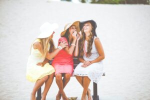 3 girls laughing and having fun sitting on a bench