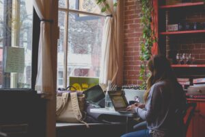 female working in cozy brick coffee shop.
