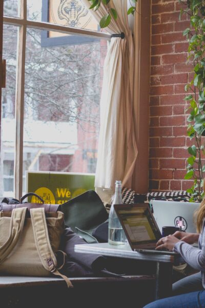 female working in cozy brick coffee shop.
