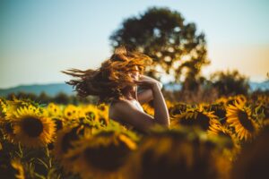girl dancing in field of sunflowers
