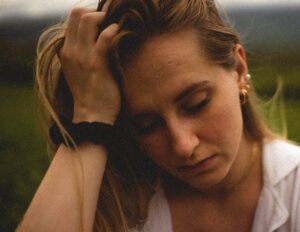 Girl holding her head in her hand with watch on wrist