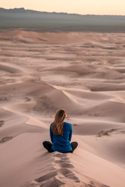 Girl sitting and reflecting in sandy dessert