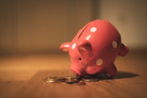 a piggy bank sniffing coins on the desk