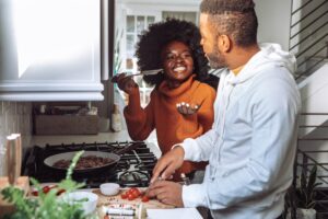 man and woman at stove cooking together