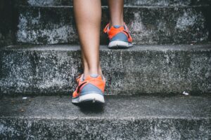 women's feet in running shoes going up the stairs
