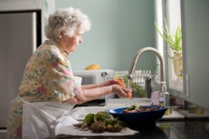 old lady at a sink washing dishes