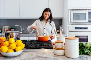 woman at stove cooking in a dutch oven