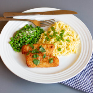 white plate with fish sticks, cheesy pasta, and peas
