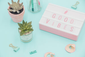 Light sign saying Good Vibes, teal and pink