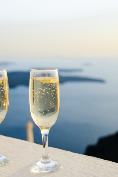 2 glasses of Champaign overlooking view of ocean and islands at sunset